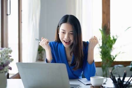 Asian Woman blogger wear blue suit talking with followers, live streaming on social media...
