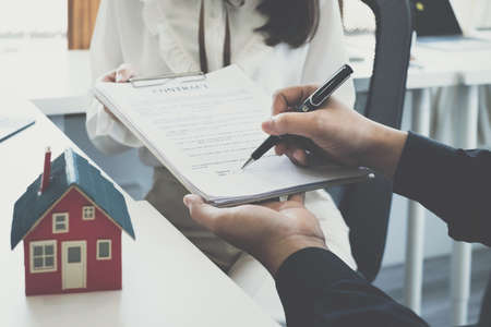 Business woman or broker give contract agreement paper to customer to sign contract. Real Estate and Agreement concept.の写真素材