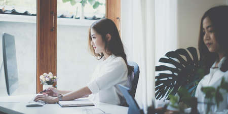 Asian business woman or accountant using computer desktop talk to colleagues for briefing business plan in video call. finance fund investment concept.の写真素材