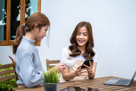 Friends Teenager Buddies Concept. Asian teen talking and looking at content in smart phone.の写真素材