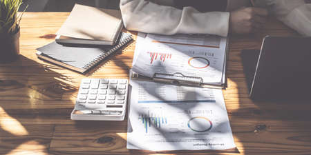 Asian Businesswoman or Accountant hands holding paperwork with calculator, account and saving concept.の写真素材