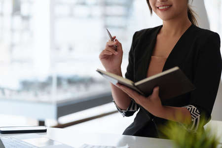 Secretary checking schedule at front of boss room.の写真素材
