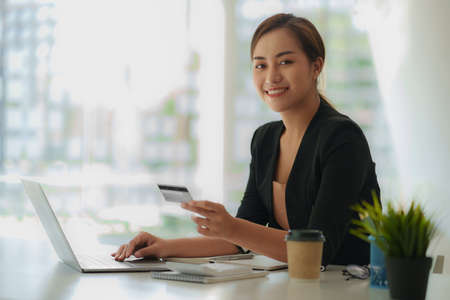 Woman using shopping web site by laptop computer and payment by credit card.の写真素材