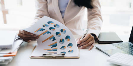 Asian Business woman working to analyze technical price graph and indicator with business team...