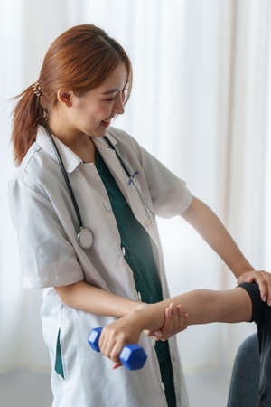 Woman doing the Rehabilitation therapy pain in clinic. Doctor or Physiotherapist. Doctor or...