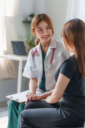 Doctor hold hand of patient and giving consolation and consultation at clinic.の写真素材
