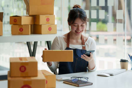 Asian small business owner working at home office. Business retail market and online sell marketing delivery, SME e-commerce concept.の写真素材