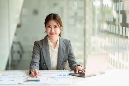 Charming Asian Business Woman talking with customer by cell phone at office.の写真素材
