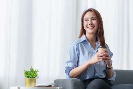 Beautiful asian woman with coffee at office.の写真素材