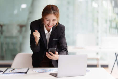 Successful business woman excited when her business growth and good news. Finance concept.の写真素材