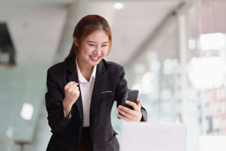 Successful business woman excited when her business growth and good news. Finance concept.の写真素材