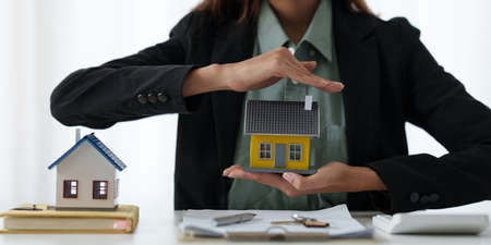 A woman holding and checking house model .Real Estate House Appraisal And Inspection and Insurance concept.の写真素材