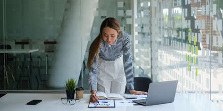 Close up Business woman hand using calculator to calculate the companys financial results and budget. Account Audit Concept.の写真素材