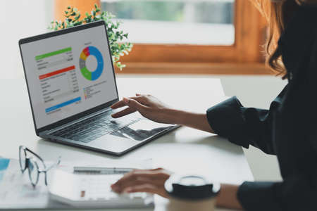 Close up Business woman hand using calculator to calculate the companys financial results and...