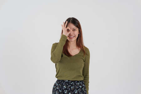 Image of happy young girl standing and Looking camera pointing isolated over white background.