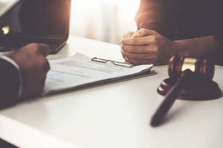 Business woman and lawyers discussing contract papers with brass scale on wooden desk in office. Law, legal services, advice, Justice concept.の写真素材