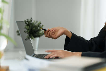 .Businesswoman in having a video call on laptop while discussion with business partner during work from home.の写真素材