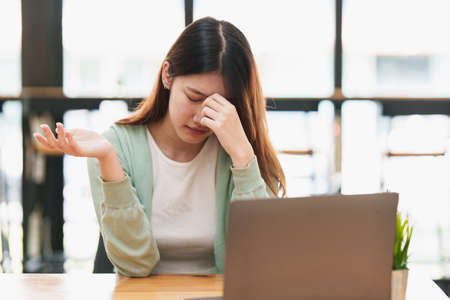 Frustrated young woman have problem while sitting at her working place. Business Stressed concept.の写真素材