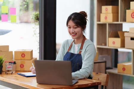 A portrait of Asian woman, e-commerce employ.e freelance with parcel box for deliver to customer. Online marketing packing box delivery concept.の写真素材