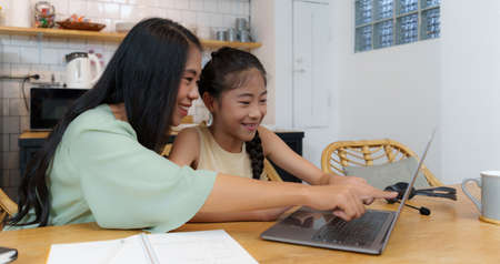 Homeschool Asian mother and little young girl student learning online class. E-learning Online...