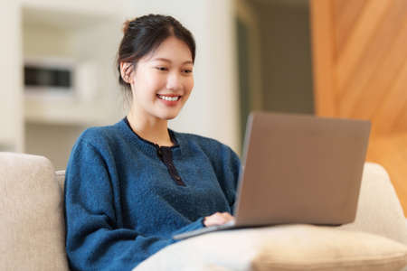 Portrait of Young Asian woman using social media by laptop. Lifestyle ,Shopping online, relax on...