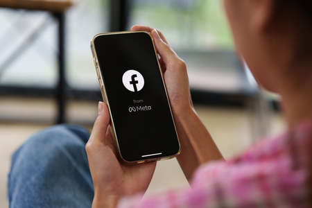 CHIANG MAI, THAILAND - MAY 26, 2022 : Facebook social media app logo from Meta on mobile app screen on iPhone 13 in persons hand working on e-commerce shopping businessのeditorial素材