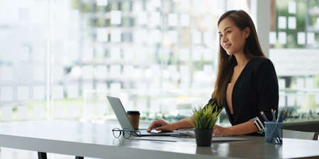 A portrait of Asian happy Businesswoman smiling and working at office.