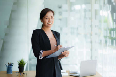 A portrait of Asian happy Businesswoman smiling and working at office.の写真素材