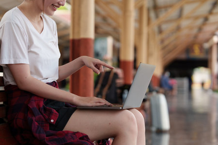 Pretty Young traveler woman excite and planning trip at train station. Summer and travel lifestyle concept.の写真素材
