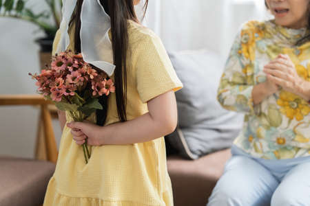 Happy moment of Little daughter surprise her loving mother on holiday by giving flowers