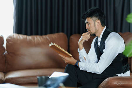 Portrait of Asian Businessman checking schedule and waiting for meet customer.の写真素材