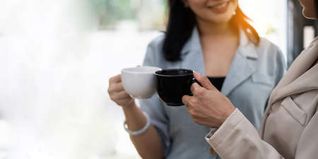 Two Young asian business woman have coffee break at office. finance and accountant Concept.の写真素材