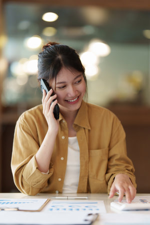Image of Young woman with a cell phone working online on laptop computer. studying or working from home online concept.の写真素材