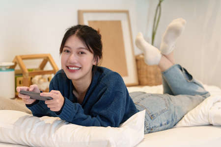Young woman playing games on smartphone. Woman using video streamning. technology and people...