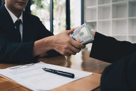 Partner give bribe money in envelope to another businessman. Corruption and Anti Bribery concept.
