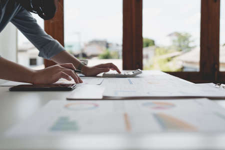 Close up Business woman using calculator for do math finance on wooden desk in office and business...
