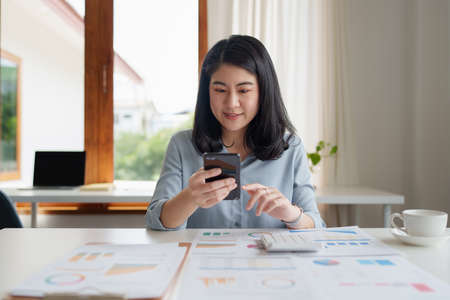 A businesswoman completes KYC using an online banking program in order to open a digital savings account. The definition of cyber security.の写真素材
