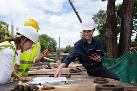 Structural engineer and architect discussing and working with blueprints at the outdoors...