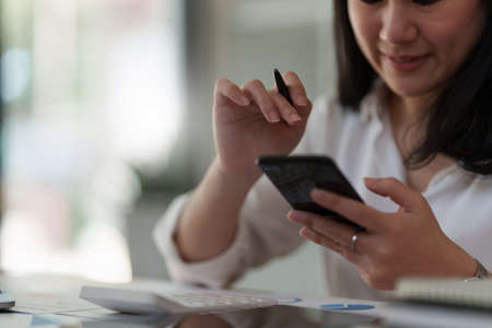 A businesswoman completes KYC using an online banking program in order to open a digital savings...