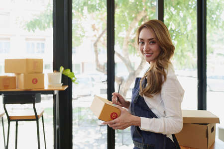 Attractive Asian SME business woman working at home office. online shopping concept