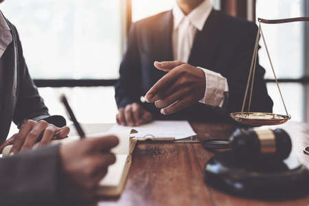 Business woman and lawyers discussing contract papers with brass scale on wooden desk in office. Law, legal services, advice, Justice conceptの写真素材