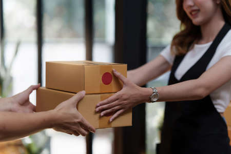 Asian woman employee freelance with parcel box for delivery to customer