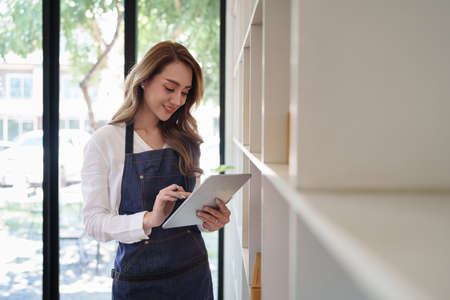 Attractive Asian SME business woman working at home office. online shopping concept