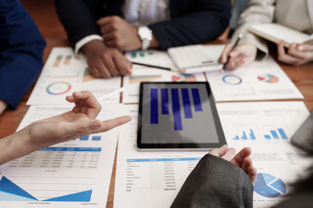 Analytics intelligence concept. Group of business people discuss current financial and economic on...