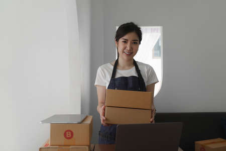 Attractive Asian SME business woman working at home office. online shopping conceptの写真素材