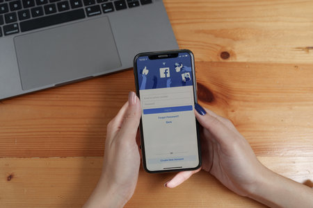CHIANGMAI, THAILAND - AUG 26, 2022 : Asian woman holds smartphone with facebook login screen. facebook from metaのeditorial素材