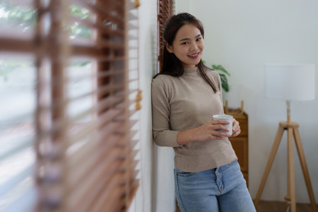 Beautiful woman relaxing and drinking coffee in morning at homeの写真素材