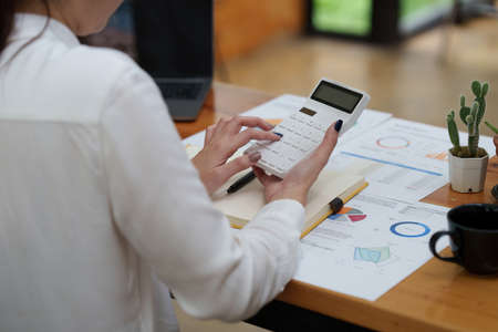 Close up Business woman hand using calculator to calculate the companys financial results and budget. Account Audit Conceptの写真素材
