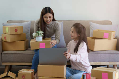 Two Asian SME business woman working at home office. online shopping concept