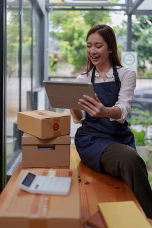 Asian SME business woman working at home office. online shopping concept